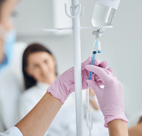 doctor adding medication to iv vial